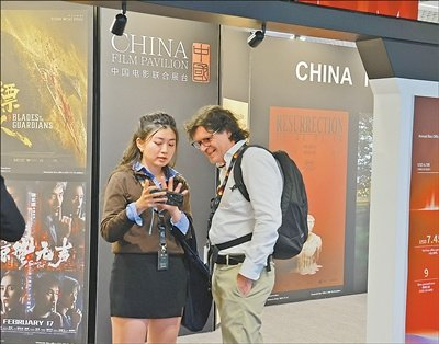  第七十九届戛纳电影节期间，中外影视从业者在“中国电影联合展台”前交流。 本报记者 尚凯元摄